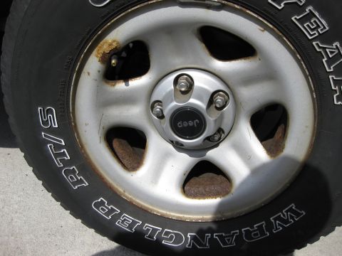 1998 Jeep Wrangler - A close-up view of a Jeep Wrangler wheel and tire, confirming the model year and brand.
