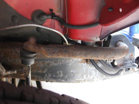 1998 Jeep Wrangler - This photo shows a close-up of a rusty tie rod end and other suspension components on a vehicle.