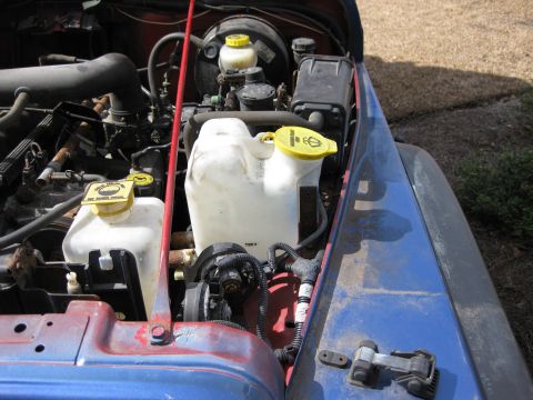 1998 Jeep Wrangler - Engine bay of a Jeep Wrangler showing the master cylinder and windshield washer fluid reservoir.