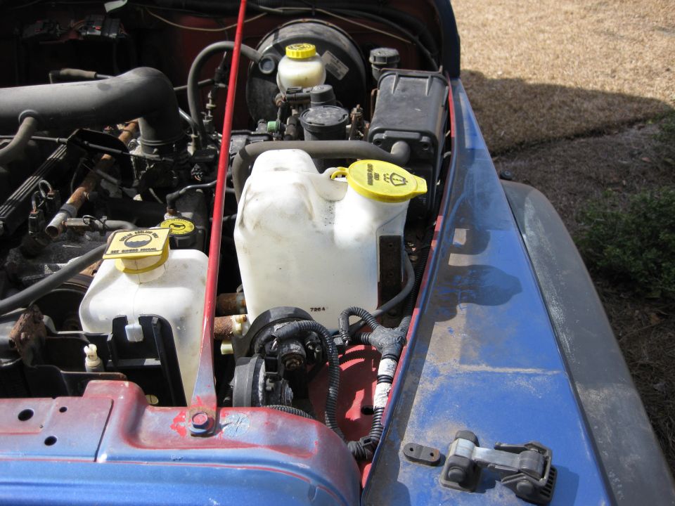 Jeep Wrangler engine bay with fluid reservoirs and wiring visible