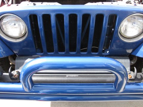 1998 Jeep Wrangler - Front view of a blue 1997 Jeep Wrangler, highlighting its iconic grille and headlights.