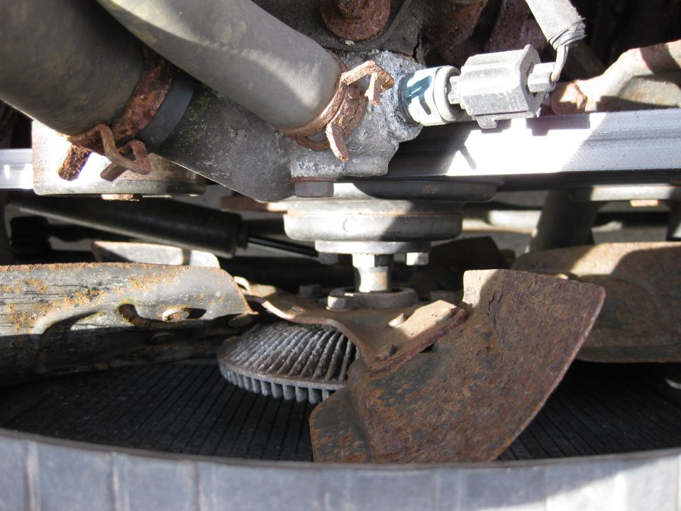 Engine fan and radiator assembly with rusty fan blades and hoses