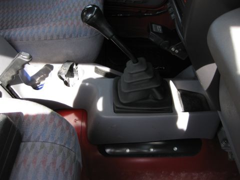 1998 Jeep Wrangler - Center console view of a 1998 Jeep Wrangler, showing the gear shifter and parking brake lever.