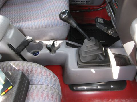 1998 Jeep Wrangler - The interior of a 1998 Jeep Wrangler features a center console with dual gear shifters and a patterned seat fabric.