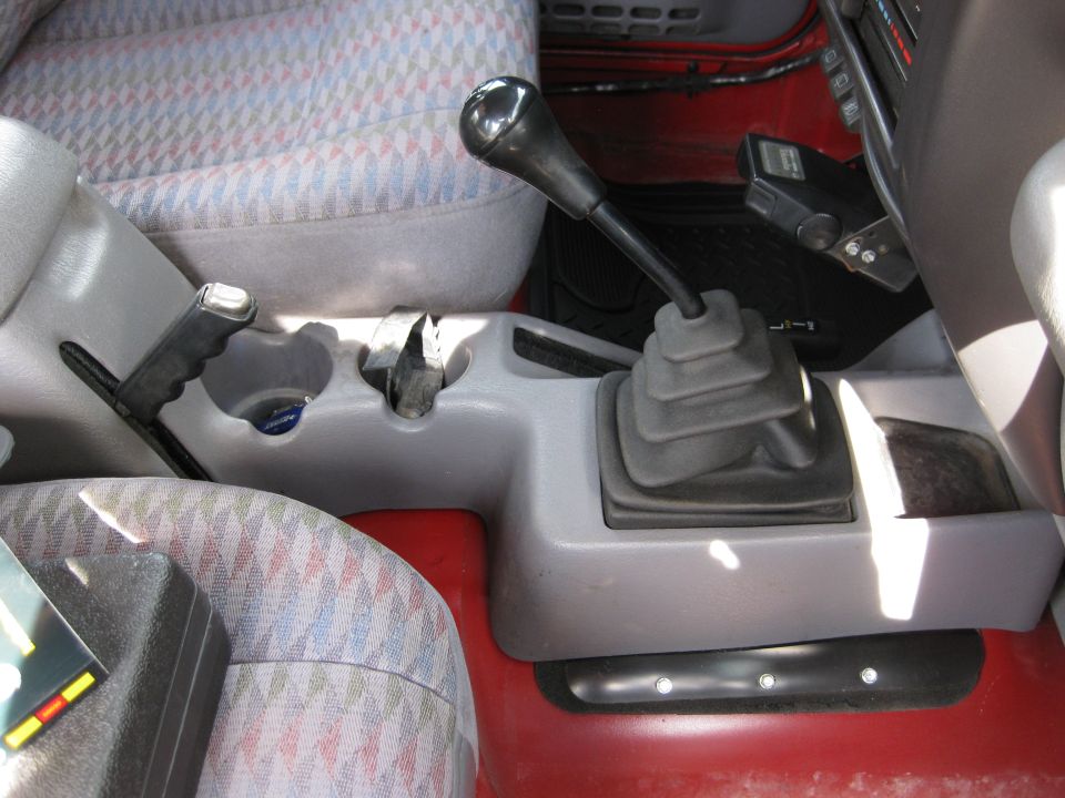 Interior shot of a 1998 Jeep Wrangler showing the center console with gear shifter, transfer case lever, and parking brake