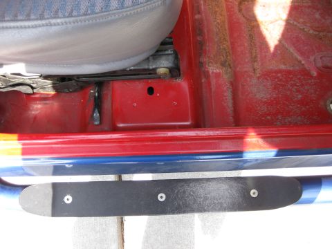 1998 Jeep Wrangler - The interior of a red Jeep is visible, with a blue and red stripe on the exterior door sill.