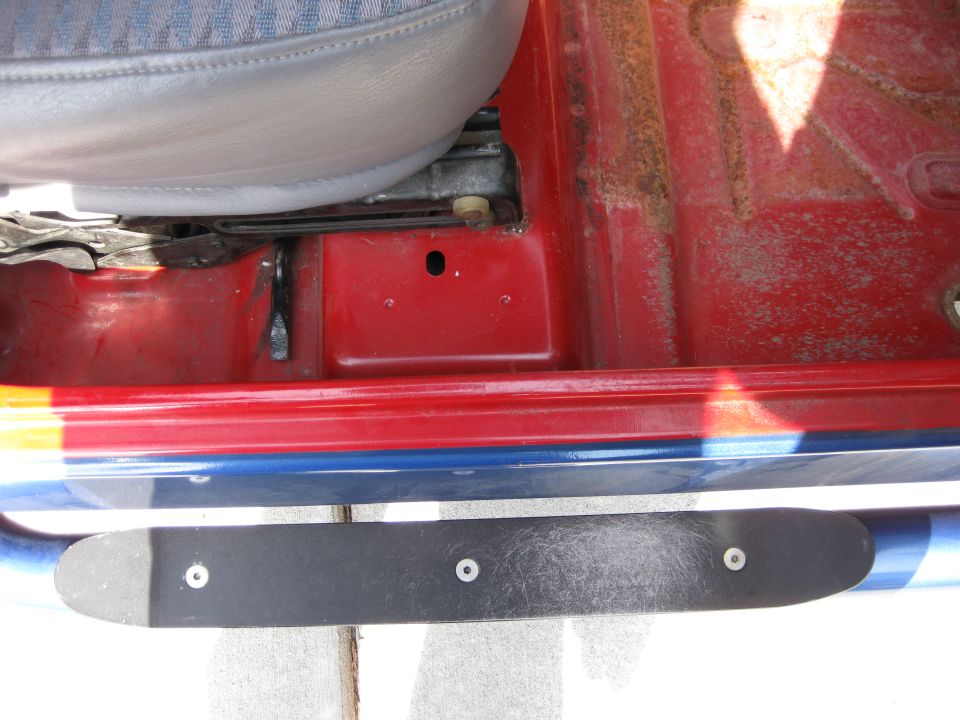Interior of red Jeep showing door sill with blue and red stripe