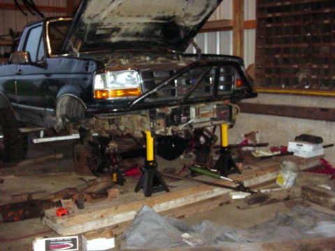 1992 Ford Bronco - This Ford truck is undergoing repairs with its front end disassembled and elevated on jack stands.