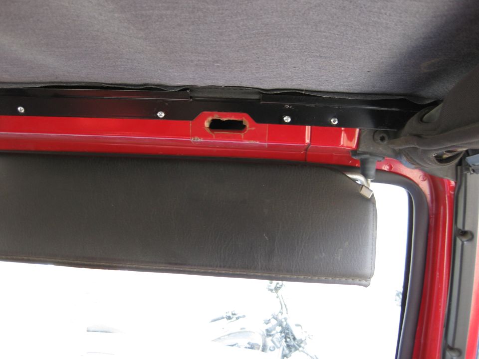 Interior view of a red Jeep showing the sun visor and headliner