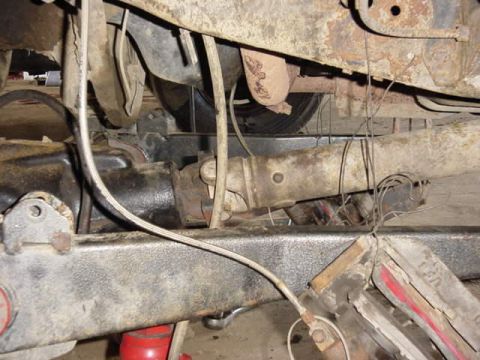 1992 Ford Bronco - Underside view of a vehicle's drivetrain components, including the driveshaft and differential.