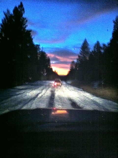 1989 Ford Bronco - Driving on a snow-covered road as the sun sets, with another vehicle visible in the distance.