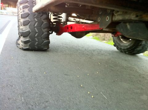 1989 Ford Bronco - Close-up view of a vehicle's undercarriage, showing its suspension and large tires.