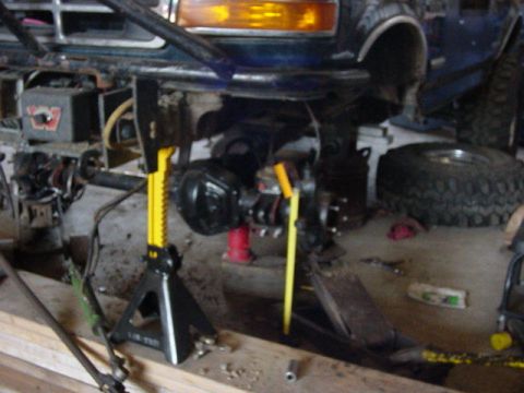 1992 Ford Bronco - The front axle assembly of a 1992 Ford Bronco is being worked on, supported by jack stands.