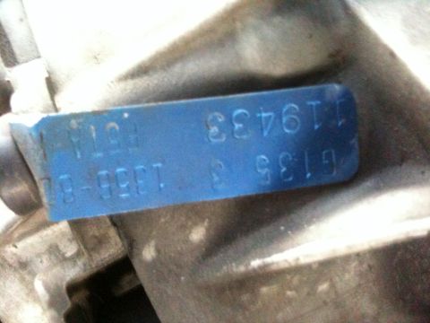 1995 Ford Bronco - A close-up view of a blue metal tag with stamped identification numbers, likely a part number or serial number.