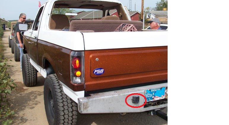 Rear view of a lifted 1989 Ford Bronco with two-tone brown and white paint