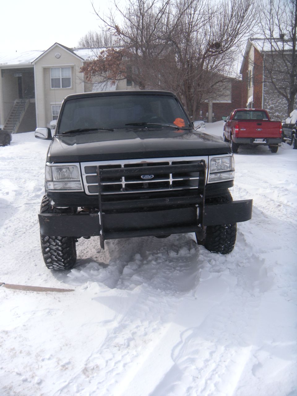 Black Ford Bronco with a brush guard in the snow, front view