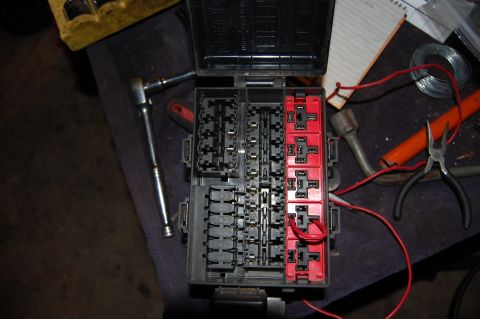 1994 Ford Bronco - Fuse box with red and black wires, pliers, and a socket wrench nearby.