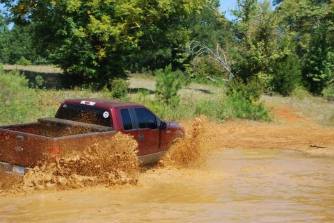 2005 Ford F-150 - This truck is kicking up a lot of mud as it drives through a water obstacle.