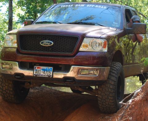 2005 Ford F-150 - A maroon Ford F-150 truck navigates a challenging off-road course.