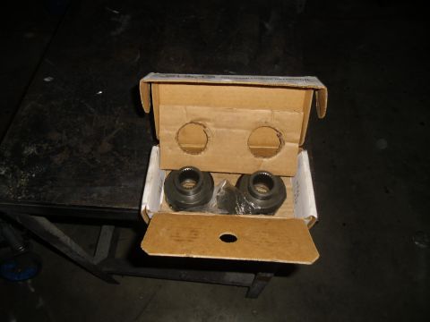 1992 Jeep Wrangler - Two metal differential lockers are shown inside a cardboard box, resting on a dark surface.