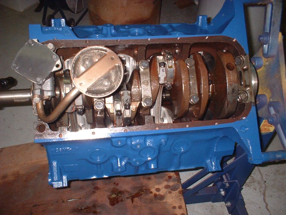 Engine block with crankshaft, connecting rods, and oil pump assembly. Block is painted blue