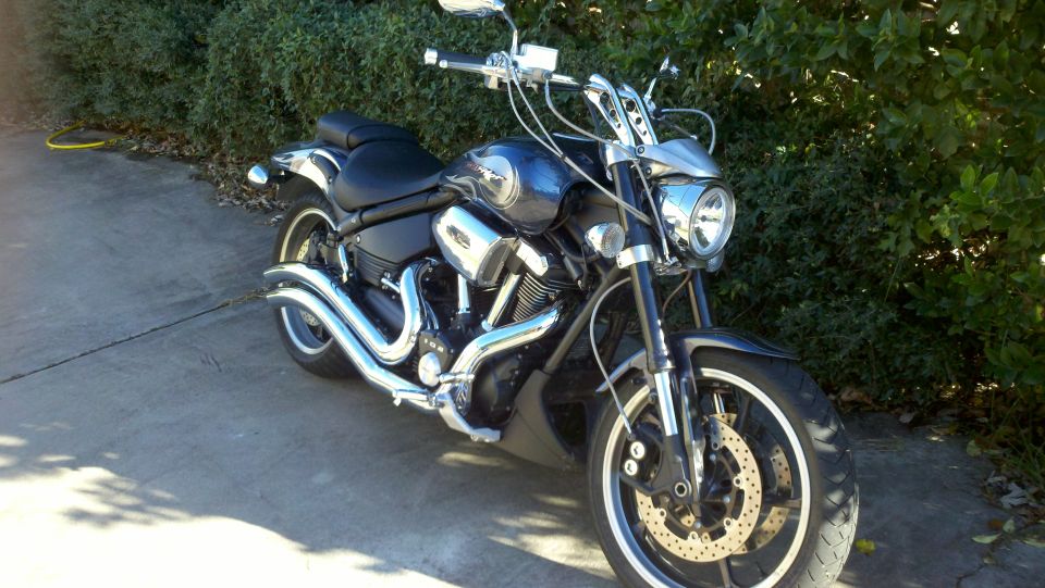 Dark blue motorcycle with chrome accents parked on a driveway