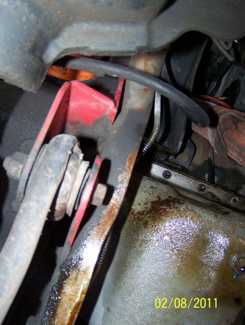 1995 Ford Bronco - Close-up of the undercarriage of a 1995 Ford Bronco, highlighting suspension components and the oil pan.