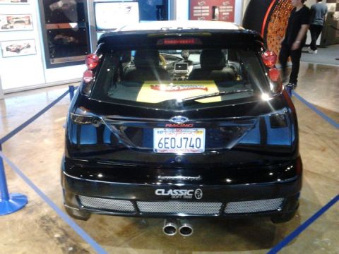 1995 Ford Taurus - Rear view of a black hatchback with a racing decal on the rear window.