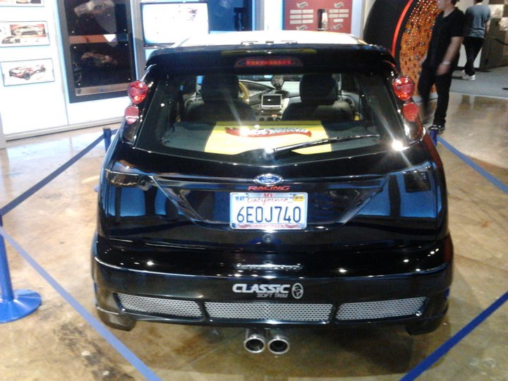 Black hatchback with dual exhaust pipes and a California license plate reading 6EOJ740