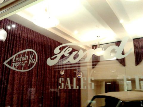 1995 Ford Taurus - A view through a dealership window shows etched logos for Ford and Lincoln Zephyr V12, along with the word SALES.