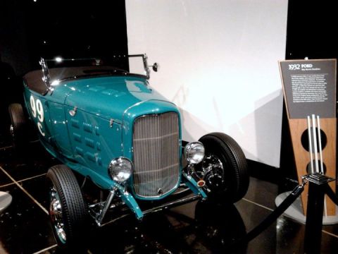 1995 Ford Taurus - A teal 1932 Ford hot rod is displayed indoors with a descriptive plaque nearby.