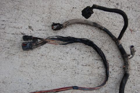1994 Ford Bronco - A damaged wiring harness with several connectors and frayed wires is shown against a concrete surface.