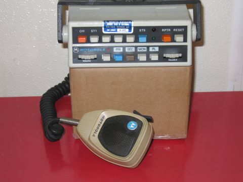 2001 Ford Crown Victoria - A Motorola radio unit and its microphone are shown, resting on a cardboard box.