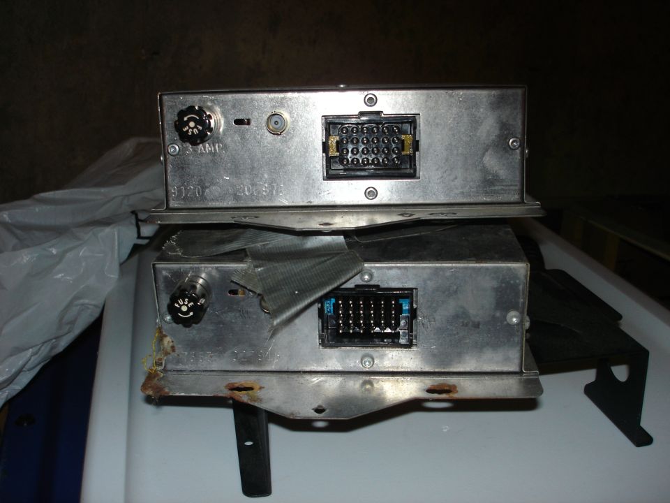 Two old car stereo units stacked, showing rear connectors and knobs