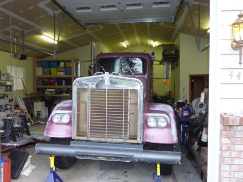 1959 Kenworth W900A - Front view of a purple 1959 Kenworth W900A truck undergoing restoration inside a garage.