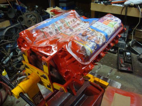 1989 Ford Bronco - Engine block is covered with newspaper and blue tape before being painted red.