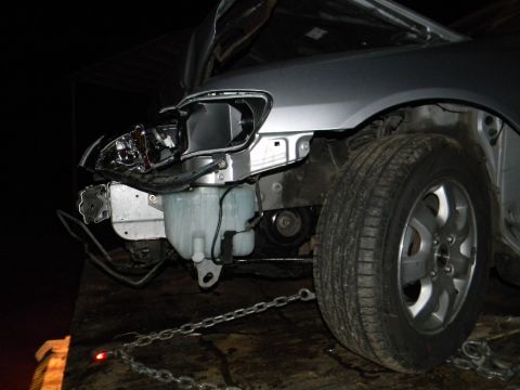 1975 Ford Ranchero - Front end damage on a car, possibly being towed on a flatbed trailer.
