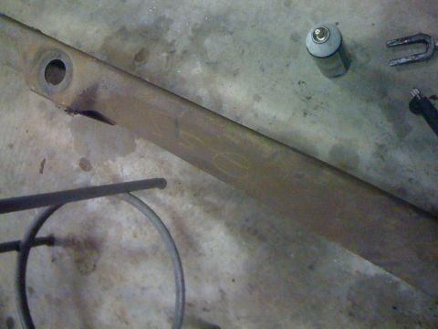 1986 Ford F-150 - A metal beam with visible markings and a hole rests on a concrete surface.