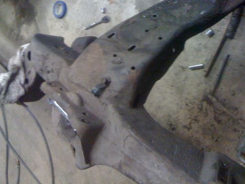 1986 Ford F-150 - A close-up view of a truck frame, showing signs of wear and tear, with tools scattered around the work area.