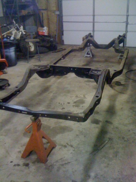 1986 Ford F-150 - Vehicle frame disassembled and supported by jack stands in a workshop.