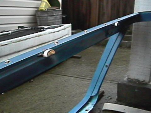 1985 Ford Bronco - A section of blue metal framing, possibly from a vehicle or structure, is shown with fasteners.