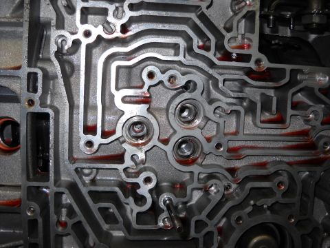 1993 Ford C-150 (Centurion Conversions) - Detailed view of an automatic transmission valve body, showing the intricate channels and ports where hydraulic fluid flows.
