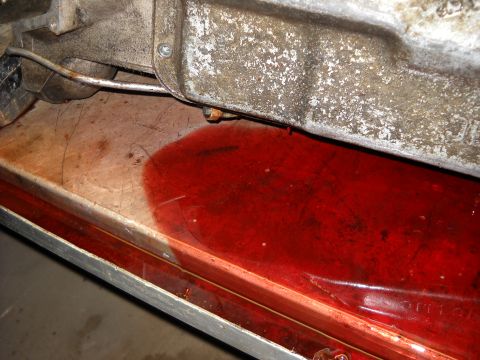 1993 Ford C-150 (Centurion Conversions) - A transmission fluid leak is visible on a metal surface beneath a vehicle component.