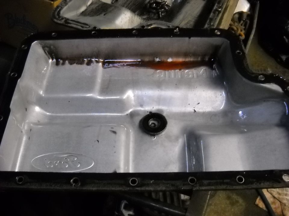 Ford transmission pan with dark fluid residue and Ford logo
