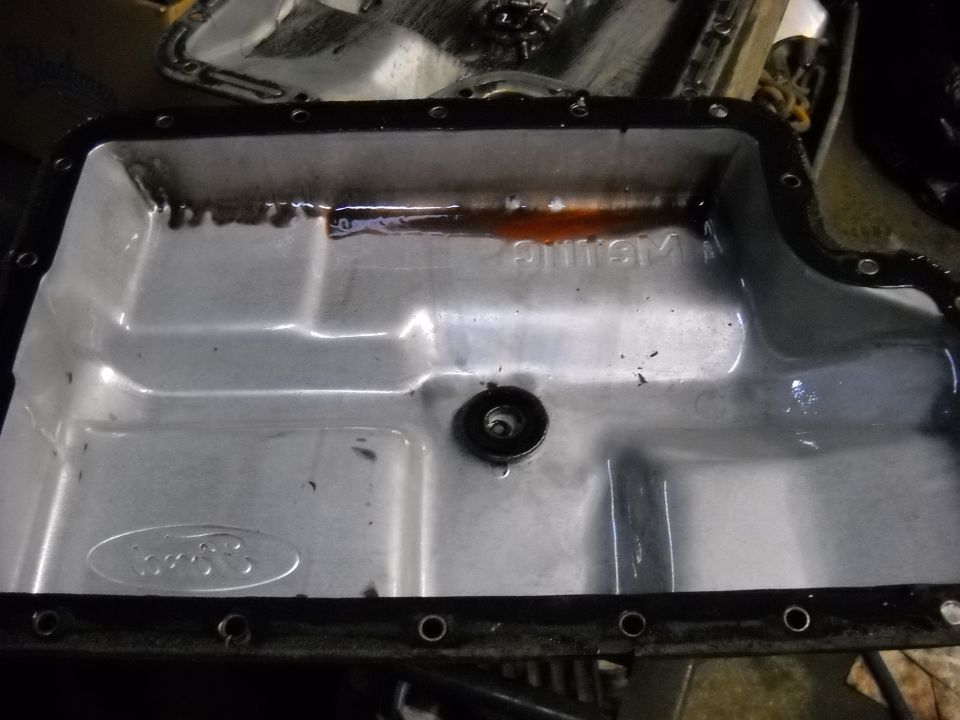 Transmission pan with Ford oval logo and some fluid residue