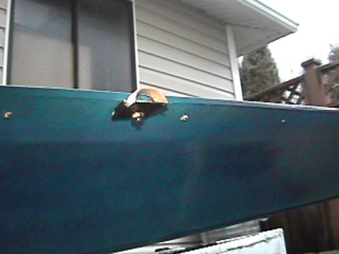 1985 Ford Bronco - A close-up view of a green panel with a latch mechanism, possibly from a boat or trailer.