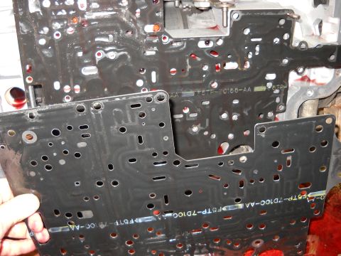 1993 Ford C-150 (Centurion Conversions) - Close-up of a transmission valve body, showing part numbers F5TP-7D100-AA and F6TF-C186-AA.
