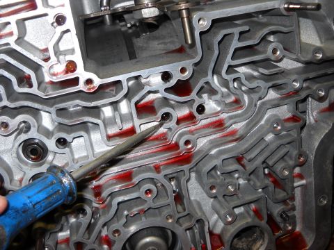 1993 Ford C-150 (Centurion Conversions) - Automatic transmission valve body with red fluid visible in its intricate channels.