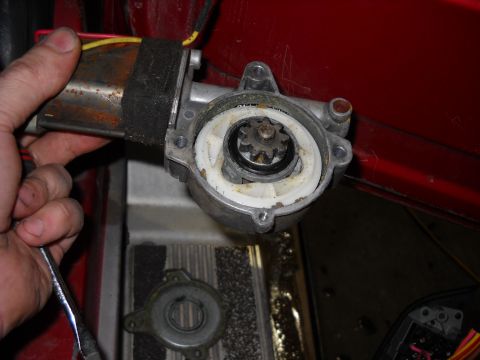 1993 Ford C-150 (Centurion Conversions) - Close-up of a disassembled power window motor unit, showing the gears and motor housing.
