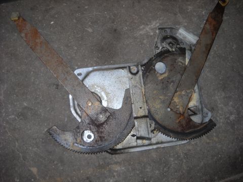 1993 Ford C-150 (Centurion Conversions) - A close-up view of a used window regulator mechanism, showing its internal gears and metal components.